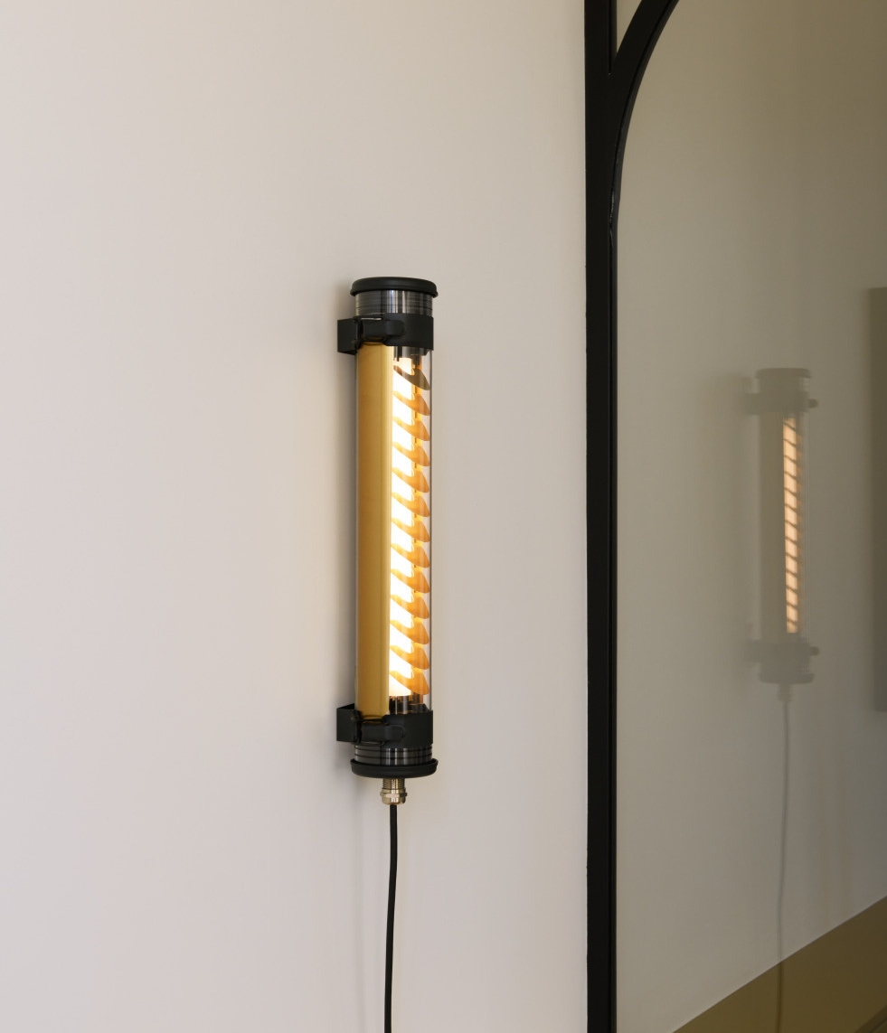 Röhren-Wandleuchte mit Stecker ELGAR PUSH: Das Modell in Schwarz mit messingfarbenem Lamellenreflektor