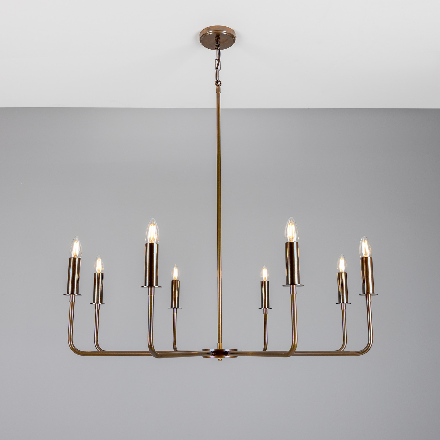 Modern Chandelier with Eight Brass Arms and Candle Bulbs: Alt-Messing patiniert