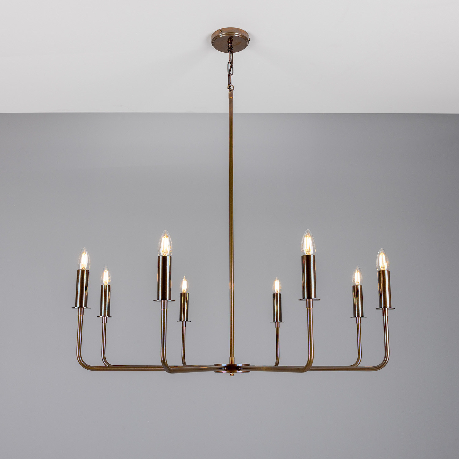 Modern Chandelier with Eight Brass Arms and Candle Bulbs: Alt-Messing patiniert
